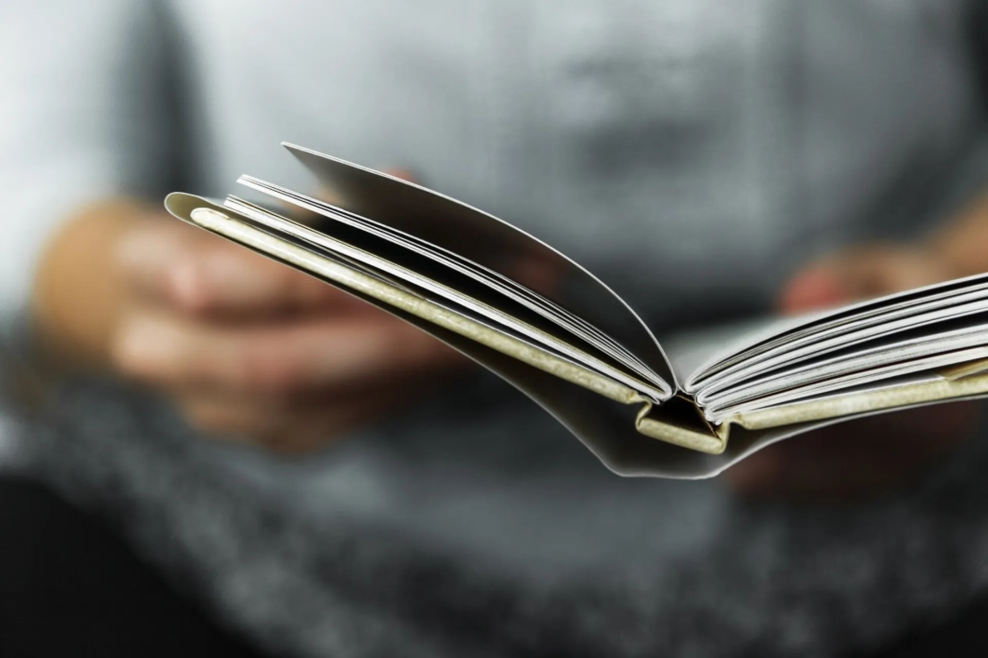 Een persoon bladert door een boek.