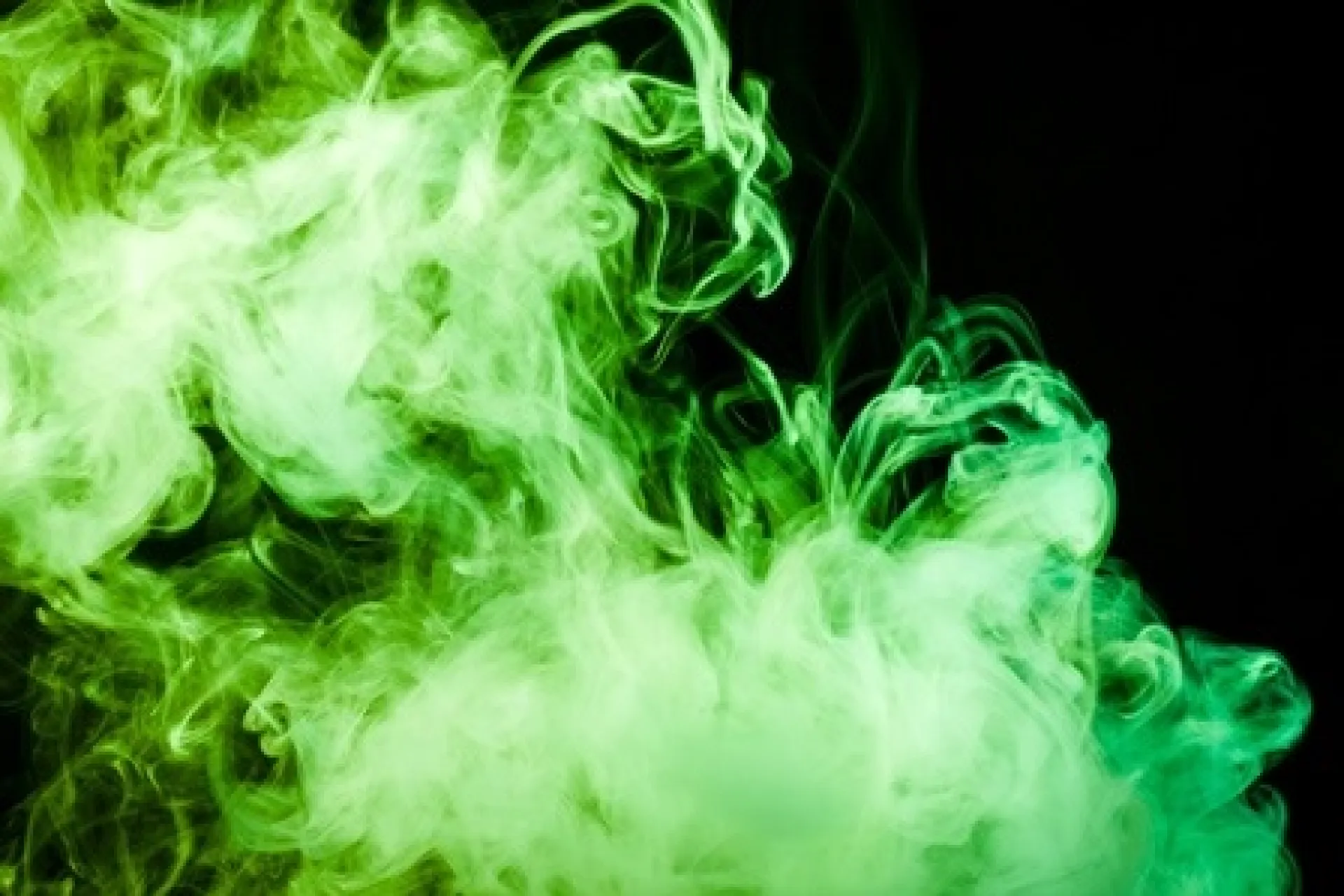 Groene rookwolken tegen een donkere achtergrond.