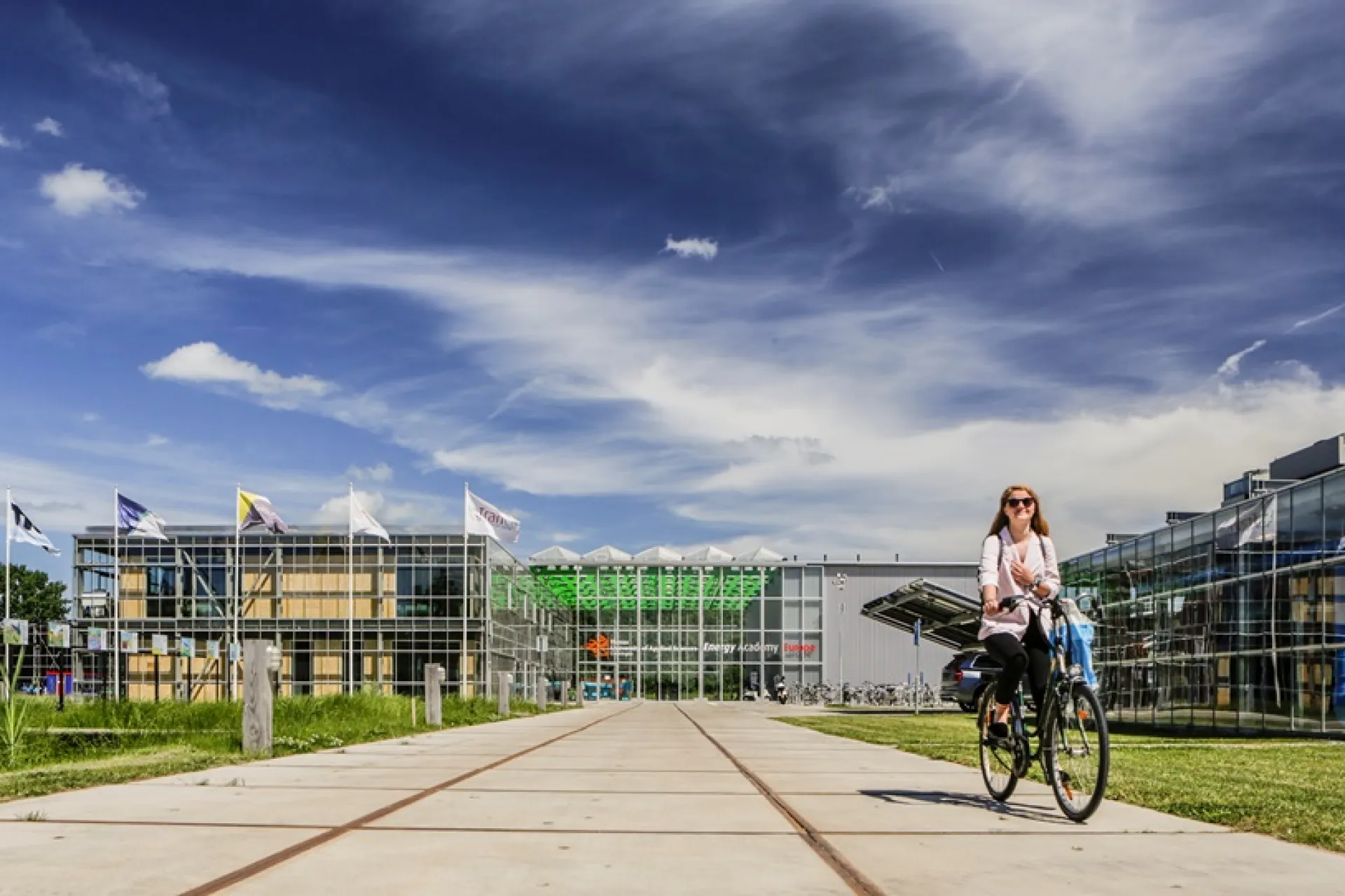 Vrouw fietst op een zonnige dag over het terrein van Entrance