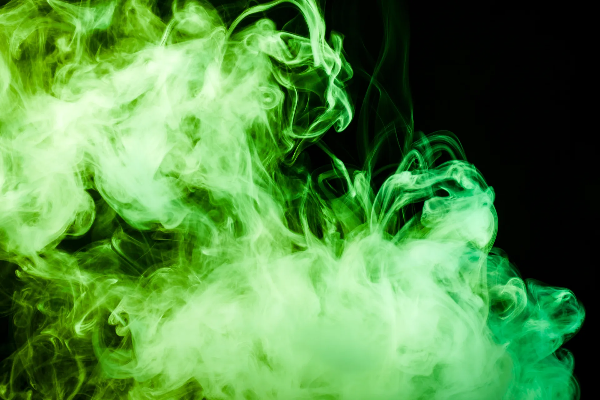 Groene rookwolken tegen een zwarte achtergrond.