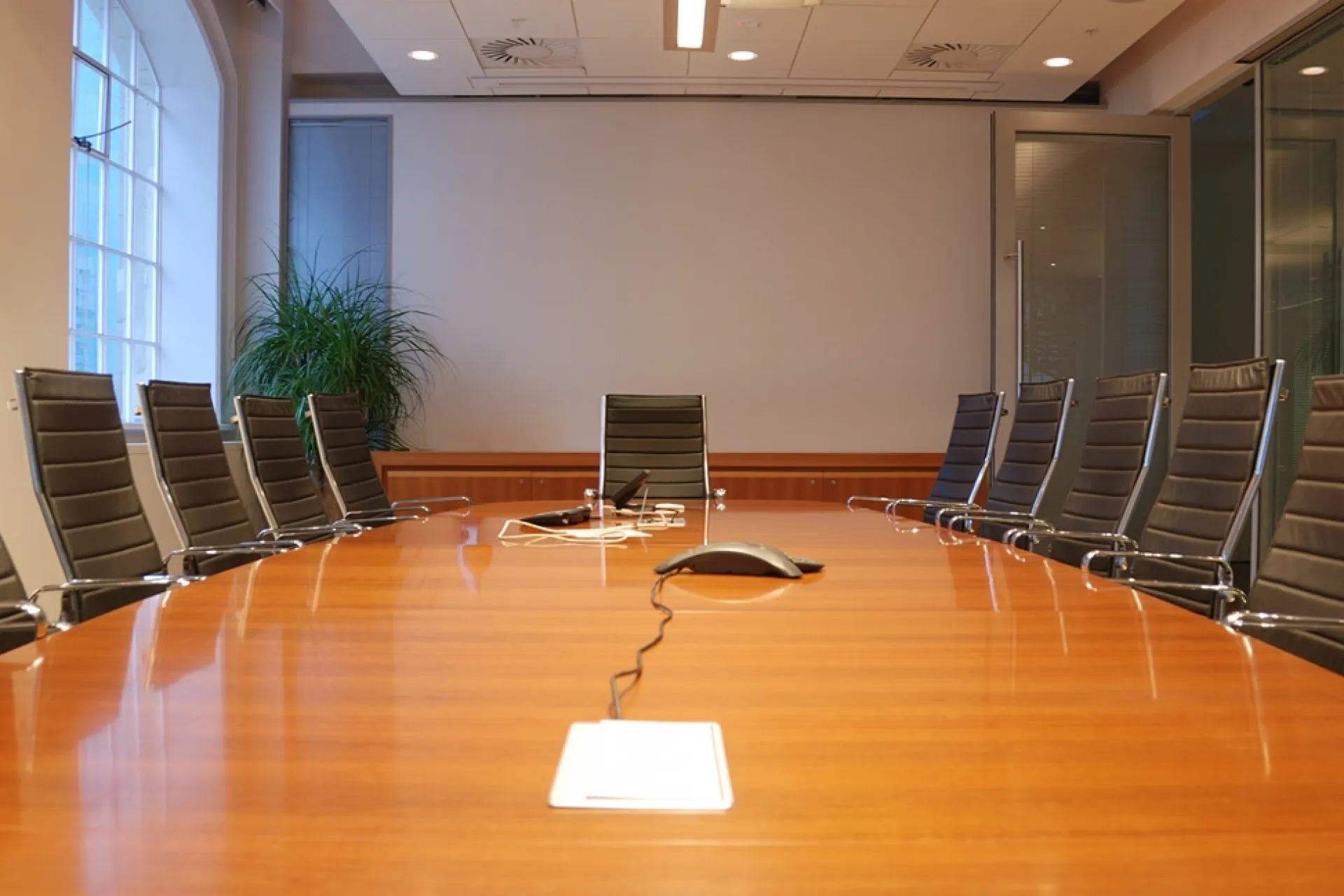 Een lege vergaderruimte met een lange tafel en stoelen eromheen